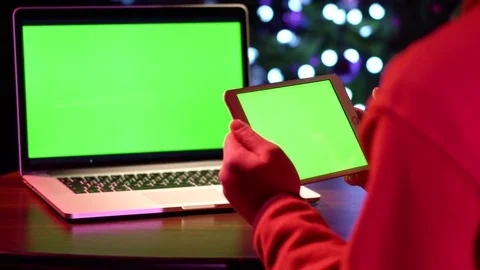A man works for laptops and a tablet with a green screen. Stock Footage 85293031
