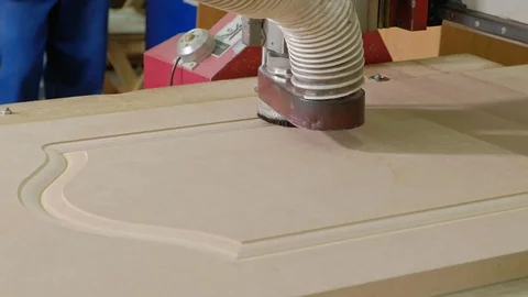 A man works at a milling machine, prepares wooden blanks for the door, the Stock Footage 100386492