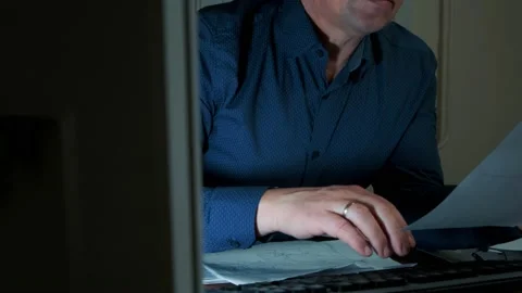 A man works at night in the office at the computer, typing on the keyboard Stock Footage 149075400