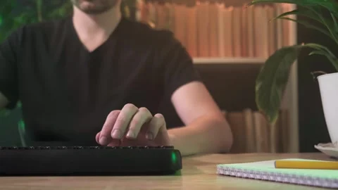 A man works in an office at a computer there are a lot of plants in the office Stock Footage 264094740