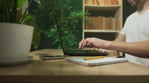 A man works in an office at a computer there are a lot of plants in the office Stock Footage 264095727