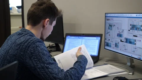Man works with papers at computer with scheme in office Stock Footage 155352999