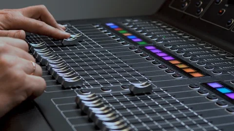 Man works on a professional electronic audio mixer. A control panel for tuning Видео 114084768