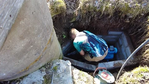 Man works on pump system in underground area for maintenance at remote site duri Stock Footage 332478181