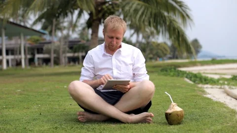 Man works on a tablet on the beach Video stock 88281390