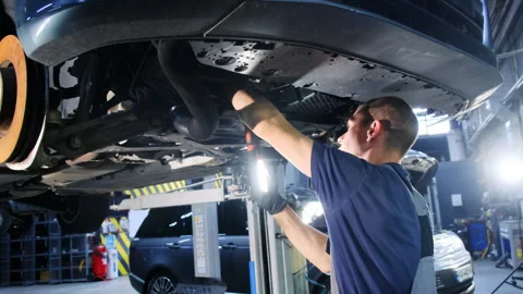 Man works under vehicle analyzing extent of malfunction Stock Footage 317628636