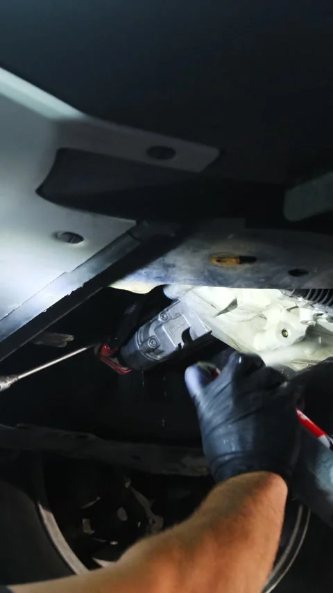 Man works on underside of vehicle during workshift Stock Footage 317652893