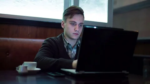 The man works by using a laptop in a cafe Stock-Footage 71352044