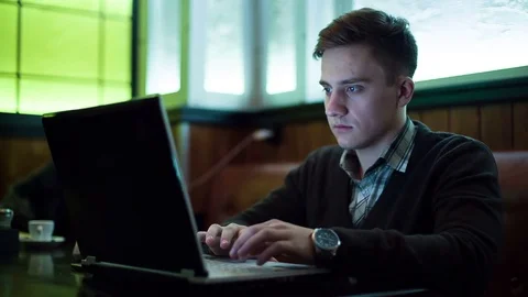 The man works by using a laptop in a cafe Stock Footage 71352254