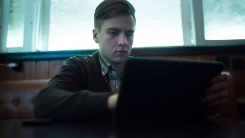 The man works by using a tablet in a cafe Stock-Footage 71352315