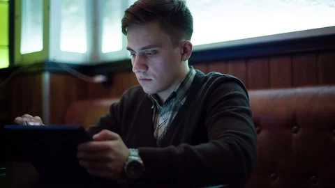 The man works by using a tablet in a cafe Stock Footage 71352363