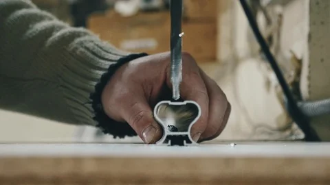 Man in the workshop drills metal. hand holding a part Stock Footage 104497725