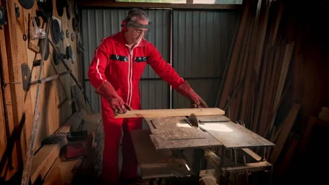 A man in a workshop is sawing a board. Video stock 318586296