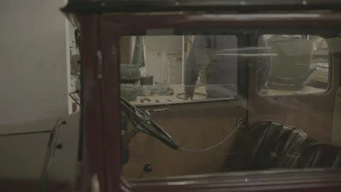 Man in workshop through classic car window Stock Footage 179977879