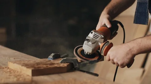 Man in workshop using a sander on a piece of oak wood Stock Footage 89306091