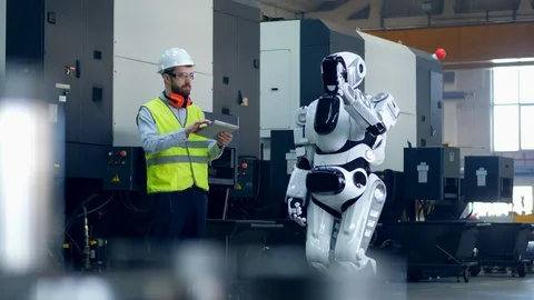 Man in workwear is operating a robot with a tablet Video stock 106845530