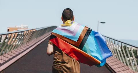 Man wrapped in a progress pride flag, web banner Stock Photos