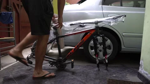 A man wrapping a bicycle with plastic to send it on a trip Stock Footage 149209946