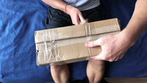 Man wraps a cardboard box with packing tape Видео 332205121