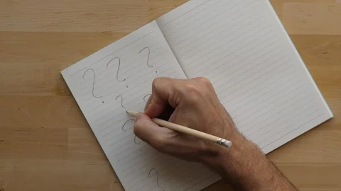 Man write many question marks on note book page, top-down shot Stock Footage 91099748