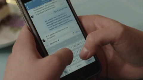 Man write massage in social network using smartphone. Man woman holds phone in Stock Footage