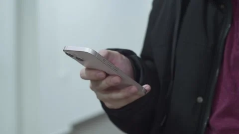 A man writes and scrolls through his phone while standing. Stock Footage 265573849