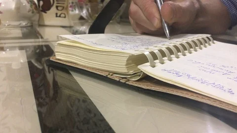 A man writes in a diary Video stock 120350971