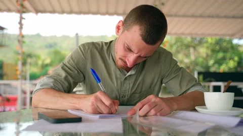 A man writes diligently with a pen in a notebook, the concept of learning. Stock Footage 231336137