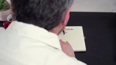 Man Writes Gratitude Lists in Journal with Markers Stock Footage 325446576
