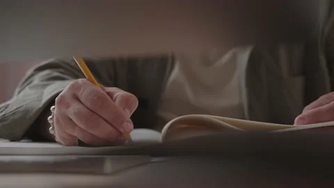 A man writes by hand in a notebook sitting in front of a computer. Stock Footage 137232498