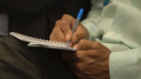 Man writes information from a lecture on business in a notebook Video stock 125889105