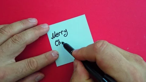 Man writes Merry Christmas note on red background Stock-Footage 286034192