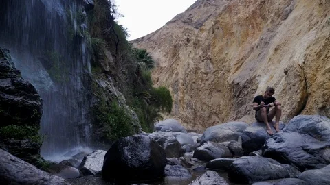 A man writes a message to social networks of the Canyon of  the Colca River Stock Footage 125287597