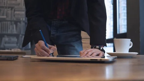 The man writes in a notebook and works on a tablet Stock Footage 86490814