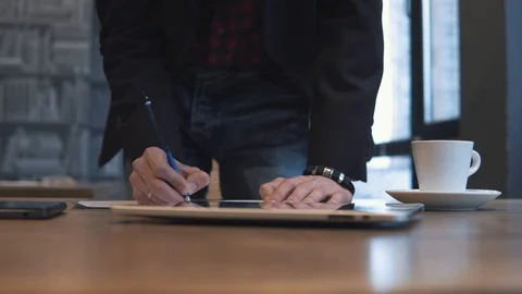 The man writes in a notebook and works on a tablet Stock Footage 86490919