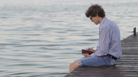 Man Writes In A Notebook Sitting By The River Stock Footage 119115434