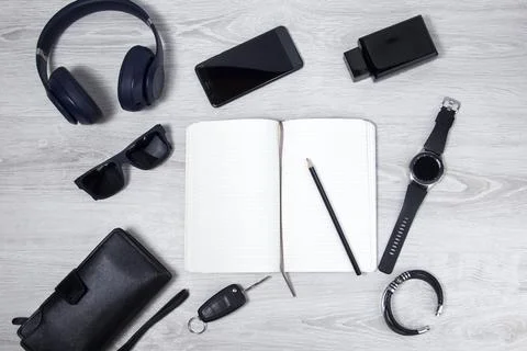 A man writes in a notebook, top view . Office desktop with various objects an Stock Photos