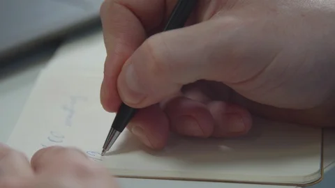 A man writes with a pen in a notebook. Close-up Stock Footage 129971555