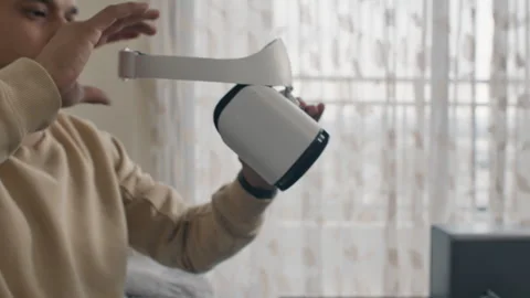 Man writes program on laptop and puts on VR headset while sitting on couch Stock Footage 310329880