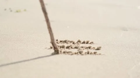 A man writes in the sand. A sunny day. Stock Footage 209496002