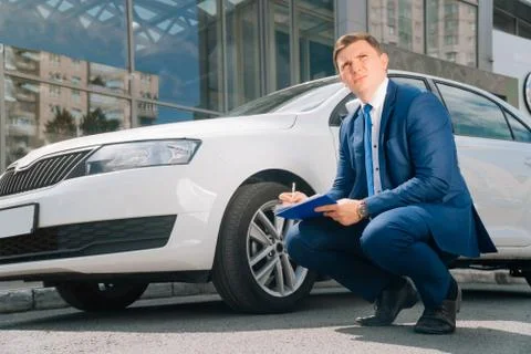 A man writes in a tablet next to the car. An accident on the road, the airbag Stock Photos