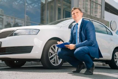 A man writes in a tablet next to the car. An accident on the road, the airbag Stock Photos