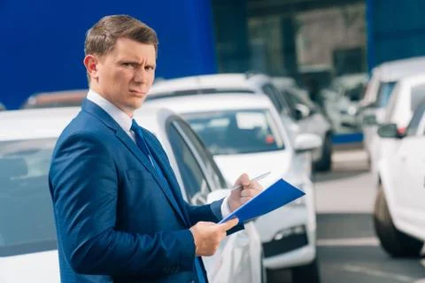 A man writes in a tablet next to the car. An accident on the road, the airbag Stock Photos