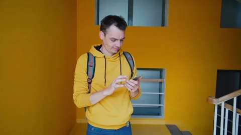 A man writes a text message on phone on the stairs hospital. health analysis Stock Footage 135589622