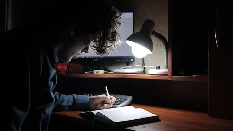 A man writes a text while sitting at a table 動画素材 125091821