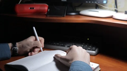 A man writes a text while sitting at a table Stock-Footage 125091877