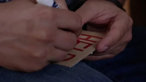 A man writes the word help on a cardboard card with a red felt-tip pen close-up Video stock 190080307