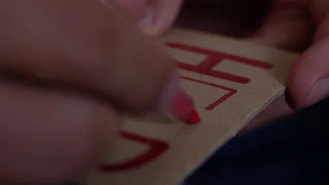 A man writes the word help on a cardboard card with a red felt-tip pen close-up Video stock 190080840