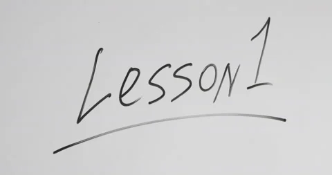 Man writes the word LESSON 1 with marker on the whiteboard Stock Footage 145023175