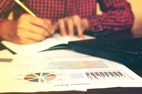 Man writing and make note about cost anual and expenses at home office. Fin.. Stock Photos